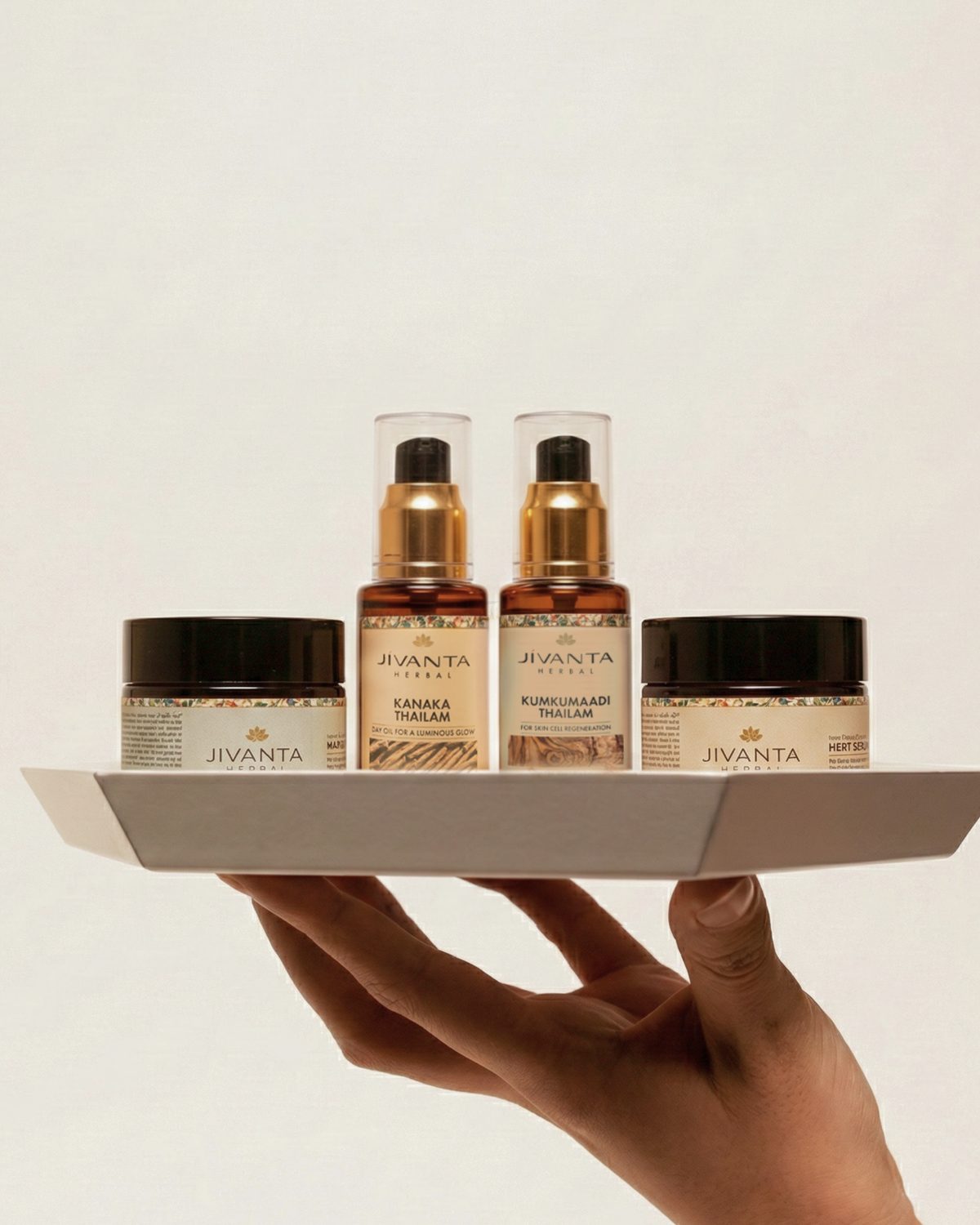 A hand holding a tray of Jivanta Herbal oils and creams